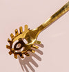 Gold pasta server close-up, serving spoon detail