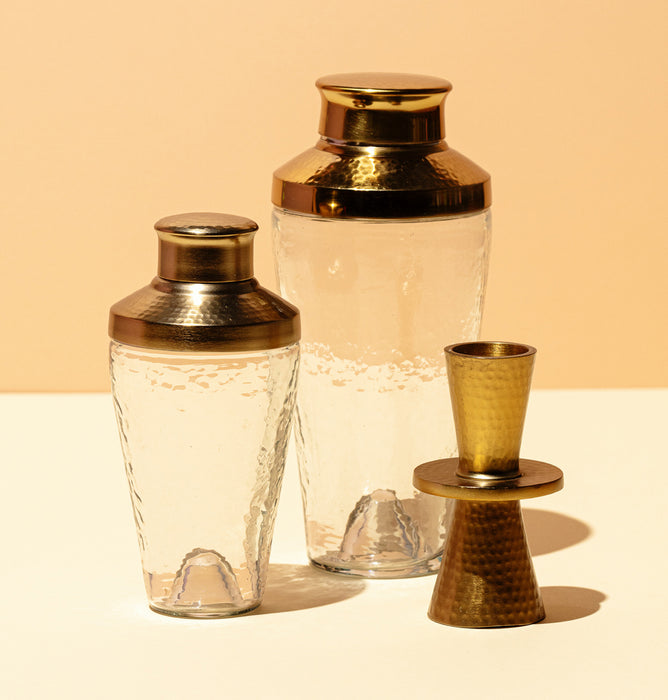 Cocktail shaker in pebbled glass with brass hammered finish. 