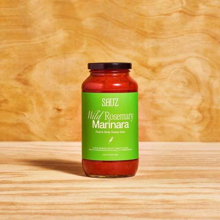 Sauz Wild Rosemary Marinara in a glass jar with a fresh green label, set against a warm wood background. This earthy and herbaceous tomato sauce is infused with fragrant rosemary, making it perfect for pasta, grilled meats, and rustic home cooking.