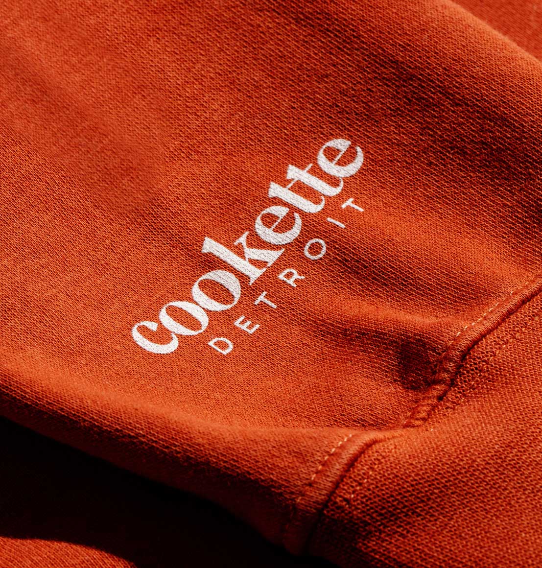 Close-up of Cookette Detroit logo screen-printed on the sleeve of Spicy sweatshirt.